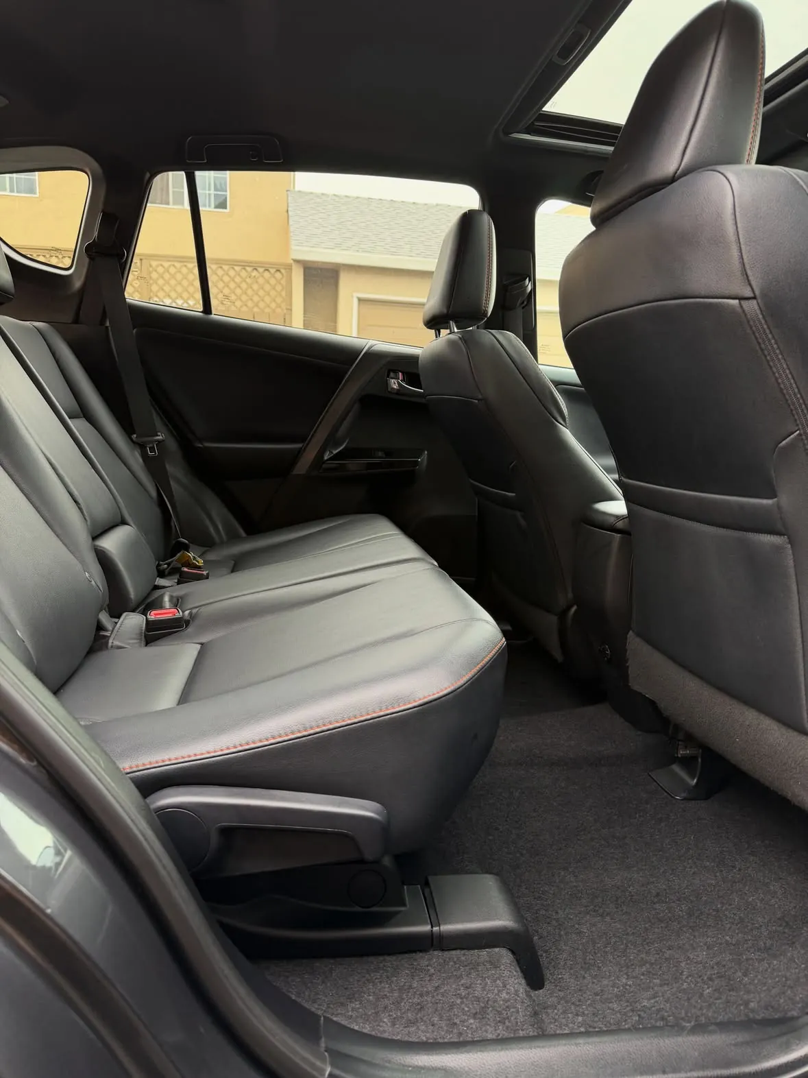 Clean black leather back seat and carpet inside a Toyota RAV4